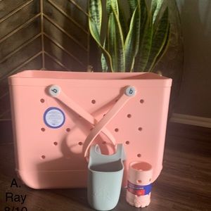 Bogg bag in peach, including bag, grey cup holder and a matching peach koozie.